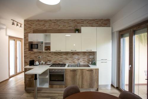 a kitchen with white cabinets and a counter top at Dimora 85 in Policoro