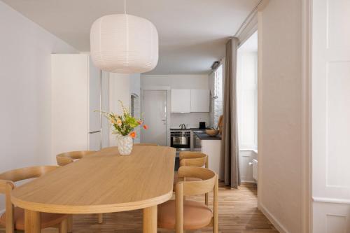 a kitchen and dining room with a table and chairs at Chic city pad with handpainted art in great location by Daniel&Jacob's in Copenhagen