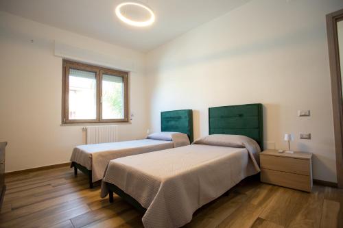 a bedroom with two beds and a window at Dimora 85 in Policoro