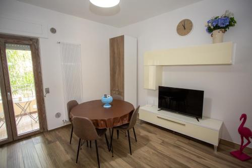 a living room with a wooden table and a television at Dimora 85 in Policoro