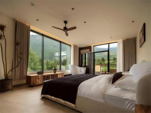 a bedroom with a large bed and a ceiling fan at Yunshui Shenshen Rizhao Jinshan Panoramic Secret Resort Hotel in Lijiang