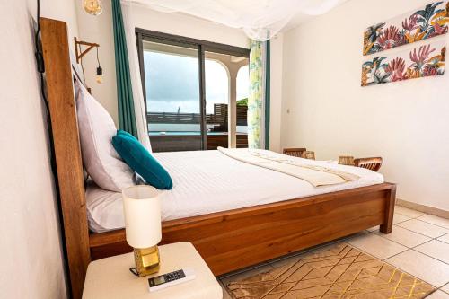 哥西尔Villa Au Coeur des Iles - Marina Gosier的一间卧室，里面有一张床和一扇窗户。