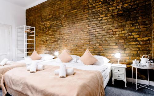 two beds in a room with a brick wall at Downtown Bratislava B&B in Bratislava