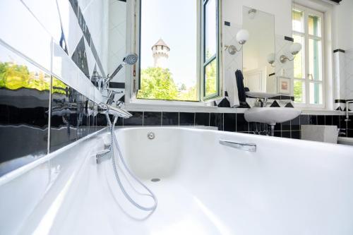 a white bath tub in a bathroom with a sink at Castle Horizon Suite in Budapest