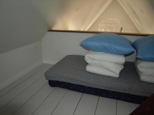 a bed with blue and white pillows in a room at Super Apartment In The First Row With A 180-Degree Sea View in Spodsbjerg