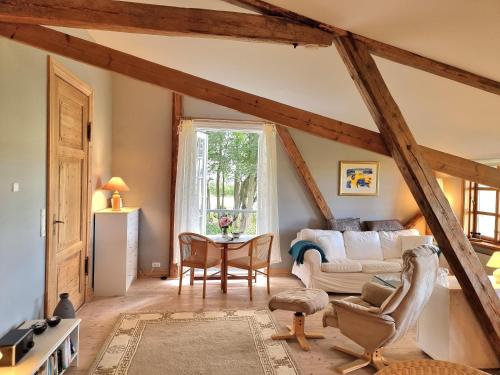 a living room with a white couch and a table at "Kornloftet", A Beautiful Home Built In The Old Barn At Frishøjgaard in Østerby