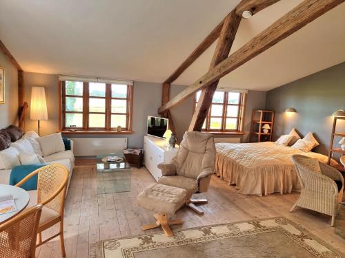 a bedroom with a bed and a couch in a room at "Kornloftet", A Beautiful Home Built In The Old Barn At Frishøjgaard in Østerby