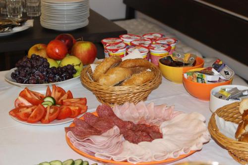 a table topped with plates of food and fruit at Hotel Amadeus in České Budějovice