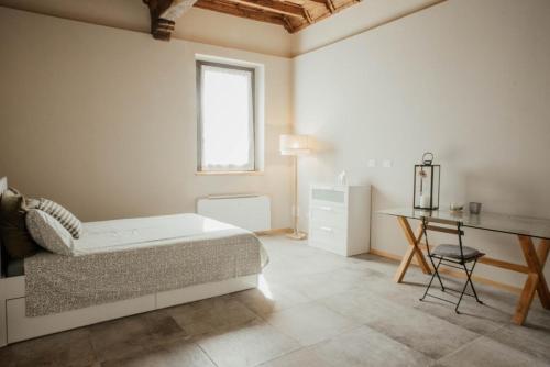 a white bedroom with a bed and a desk at La Cocca Home in Bellinzago Novarese