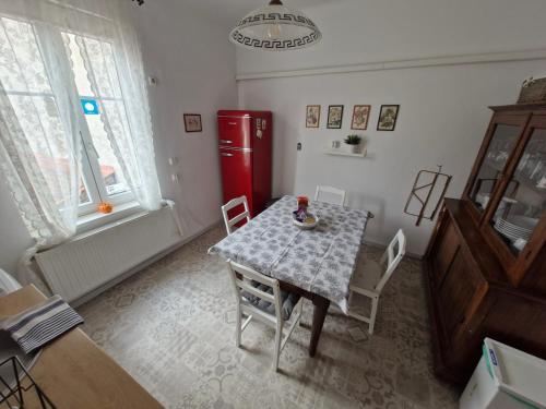 a dining room with a table and a red refrigerator at Várkerület Apartman in Sopron