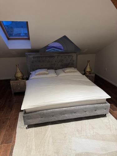 a bedroom with a large bed with white sheets at ROYAL Apartment in Kadaň