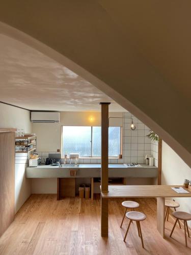 a kitchen with a table and stools in a room at Nagi Unoport 2 in Tamano