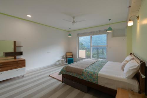 a bedroom with a bed and a large window at Better Life Homes - For active seniors above 50 years in Barog