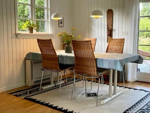 a dining room table with four chairs and a blue table at Stunning Home In Nykøbing Sjælland W in Nykøbing Sjælland