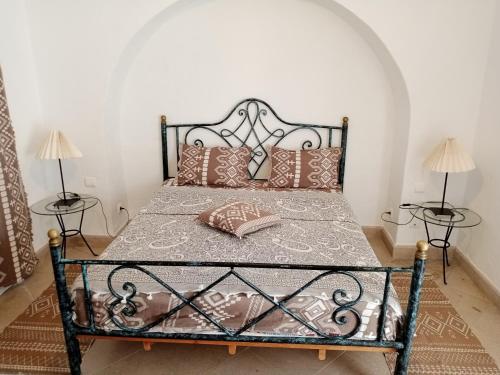 Una cama con almohadas en una habitación. en Dar El kharrouba, en Hammamet Nord