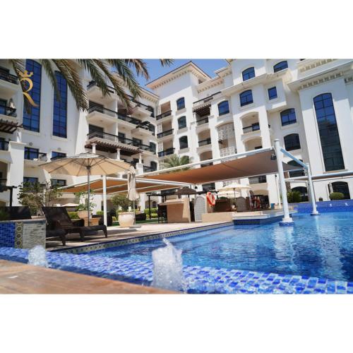 a pool in front of a building with a hotel at Elegant Studio Oasis - Yas Island Chic Retreat in Abu Dhabi