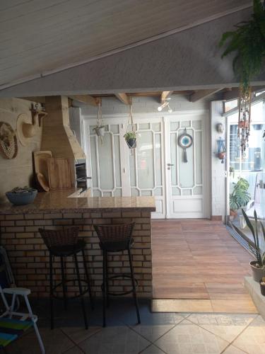 una cucina all'aperto con bar e sgabelli di Kitnet mobiliado da Nice - FUNDOS a Guaíba