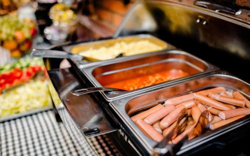 uma linha de buffet com cachorros-quentes e outros alimentos em 7Days B&B em Bratislava