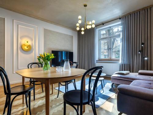 a living room with a table and chairs and a couch at Tyzenhauz Grand Apartaments in Kraków