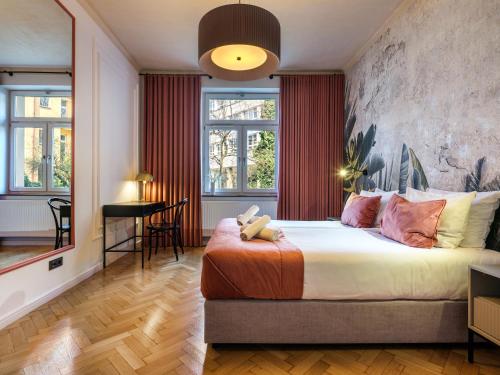 a bedroom with a large bed with a teddy bear on it at Tyzenhauz Grand Apartaments in Kraków