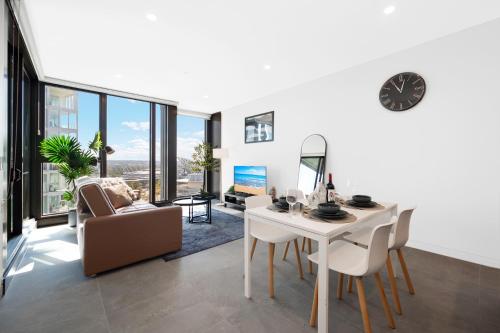 a living room with a table and chairs and a dining room at AccorView Luxury 1BR Suite Pool Gym Parking in Sydney