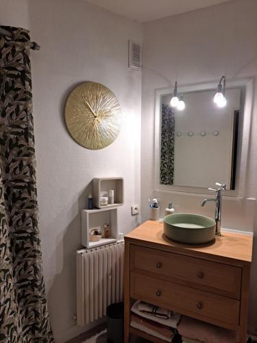 un baño con lavabo y espejo en Les grands prés, en Aytré