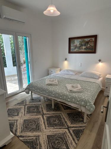 a bedroom with a bed and a large window at Barbati Villa in Barbati
