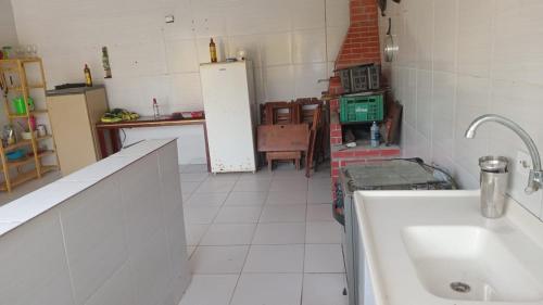 a kitchen with a sink and a refrigerator at Casa monguagua in Mongaguá