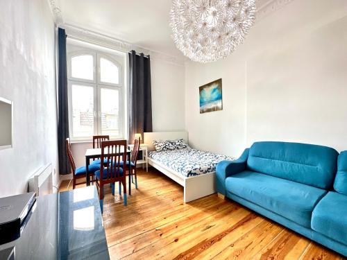 a living room with a blue couch and a table at Pokoje Monte 26 w Sopocie in Sopot