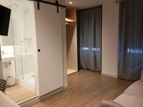 a living room with a sliding glass door with a shower at Bearan Rooms 2 in Pamplona