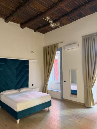 a bedroom with a bed with a blue headboard at Chiaia Lifestyle Suite in Naples