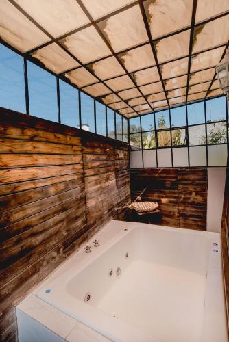 a large bath tub in a room with windows at La Casa del Atrio in Querétaro