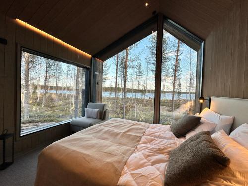una camera da letto con un letto grande e una grande finestra di Tyven Resort a Sirkkakoski