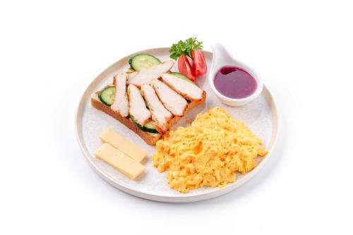 Un plato de comida con un sándwich y huevos. en Dami Almaty Hotel, en Almaty