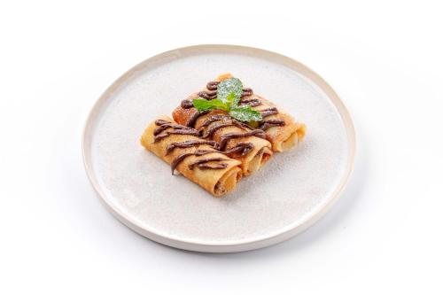 Un plato blanco con un trozo de comida encima. en Dami Almaty Hotel, en Almaty