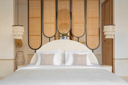 een slaapkamer met een groot wit bed met kussens bij Ocean Verve Villa 2 - 3bd in central Uluwatu in Bingin Beach