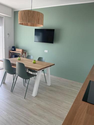 a dining room with a wooden table and chairs at Appartamento Sabbia e sogni in Pietra Ligure