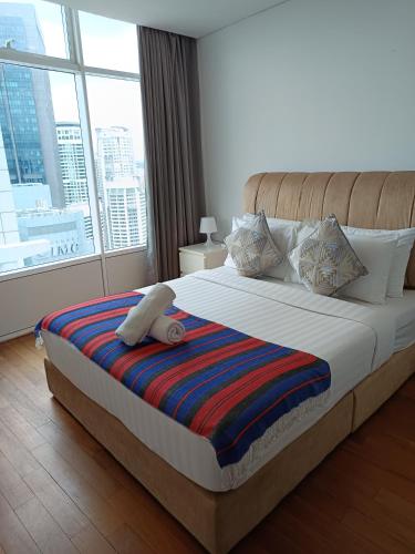 a bedroom with a large bed with a large window at KLCC Sky Villa Suites Vortex in Kuala Lumpur