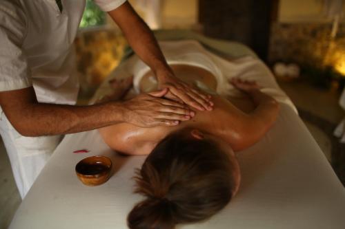 a woman getting a massage in a bath tub at The Lodge & Spa at Pico Bonito in El Pino