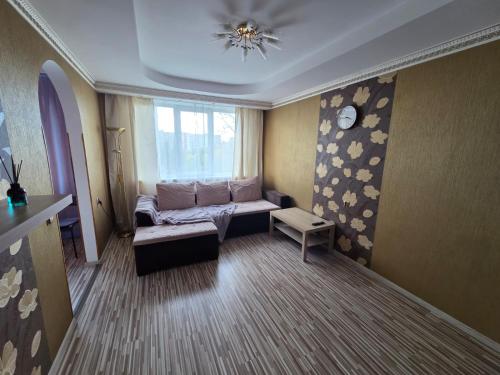 a living room with a couch and a window at Slāvu Dzīvoklis in Rīga