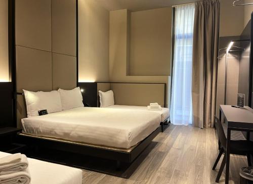a hotel room with two beds and a window at 7BA Hotel Milano in Milan