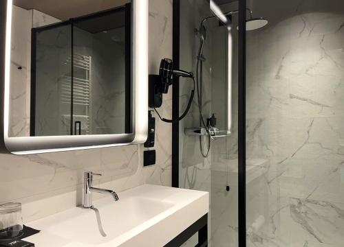 a bathroom with a sink and a shower with a mirror at 7BA Hotel Milano in Milan