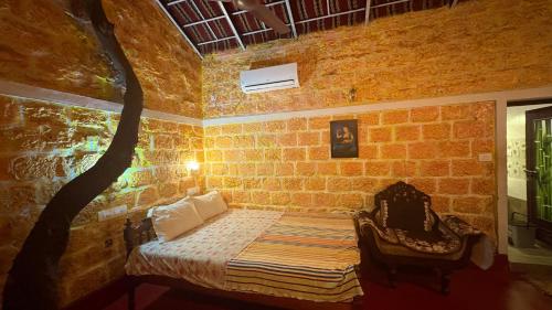 a bedroom with a bed in a brick wall at AbbA Marari Beach Villas & Homestay Mararikulam in Alleppey