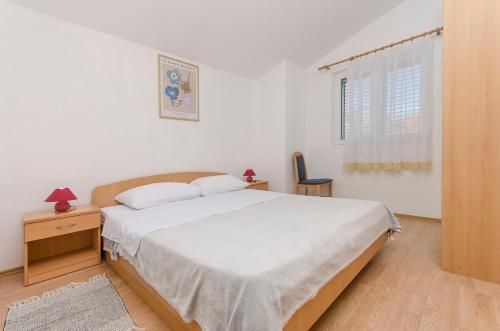 Un dormitorio blanco con una cama y una ventana. en Apartments Remi, en Nin