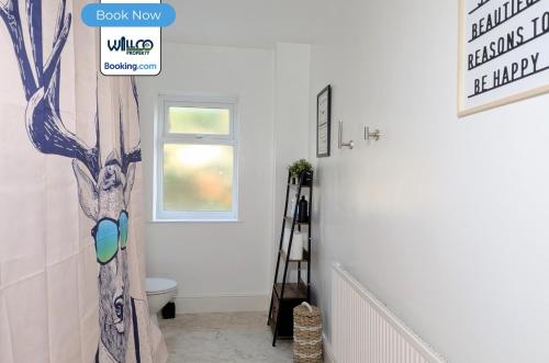 a bathroom with a toilet and a tree painted on the wall at 3 Bedroom House By WillCo Property Short Lets & Serviced Accommodation Leicester With Games, Parking, Projector & Perfect For Contractors in Leicester