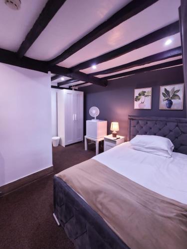 a bedroom with a large bed and a chair at The Courtyard Lodge in Hitchin