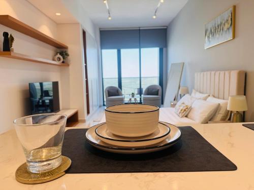 a bowl and a glass on a table in a living room at Skyleaf Studio in Dubai