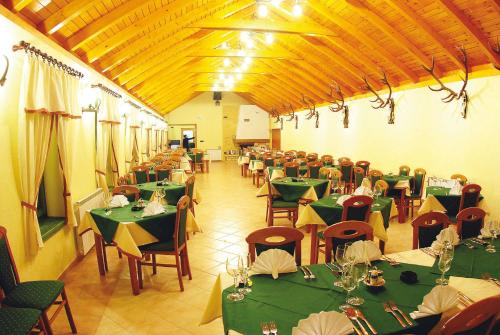 un comedor con mesas verdes y sillas en Guest accomodation Lovacka kuca, en Grdak