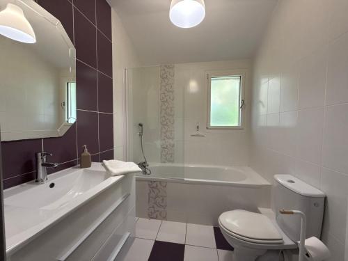 a bathroom with a tub and a toilet and a sink at Le Verger - Gite 8 personnes en campagne et rivière By Primo in La Forêt-sur-Sèvre