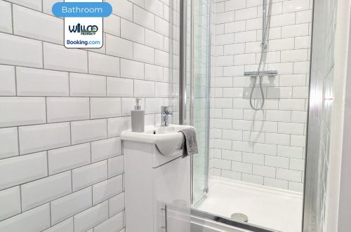 ein weißes Badezimmer mit Waschbecken und Dusche in der Unterkunft 5BR House By WillCo Property Short Lets & Serviced Accommodation Derby With Games, Parking Perfect For Contractors in Derby